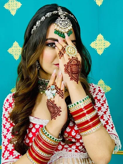 A modern bride showing off her geometric mehndi. The square patterns on the back of her hands are a chic and unconventional choice for a wedding.