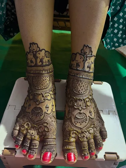 Full coverage bridal feet mehendi. This design is rich with traditional motifs, including lotuses and elephants, matching the bride's hand henna perfectly.