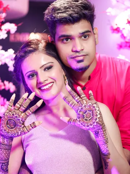 A happy couple posing with the bride's beautiful mandala mehndi. It's a design that looks great from every angle.