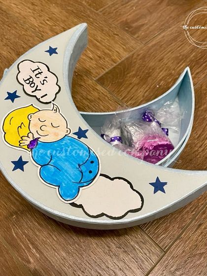 Announce the arrival of your baby boy with this charming moon-shaped gift box. The "It's a Boy!" box is perfect for holding small treats or keepsakes to share with family and friends.