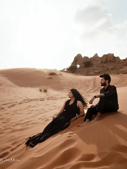 A serene moment for the couple in the Dubai desert. This wide shot captures the peacefulness of the landscape and the couple's quiet companionship.