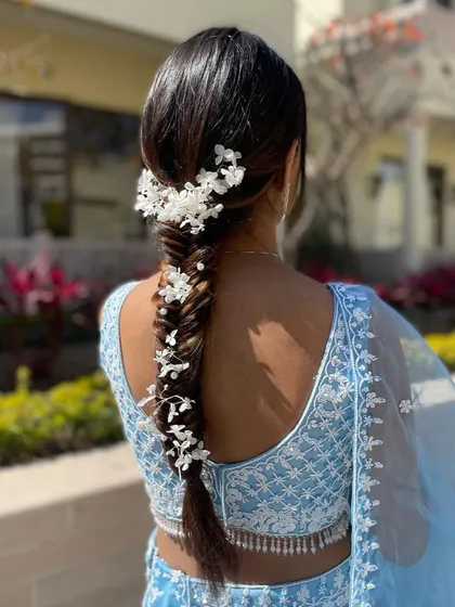 A side profile of the white floral fishtail braid. This angle highlights the delicate placement of the flowers and the clean lines of the braid.