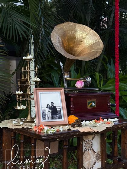 A vintage gramophone and a framed photo of the couple, creating a nostalgic and romantic corner at their wedding.