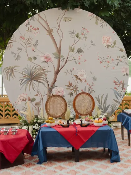 The setup for the outdoor Paebaek ceremony, featuring a custom-printed circular backdrop with traditional Korean art, and tables set with symbolic foods and items.
