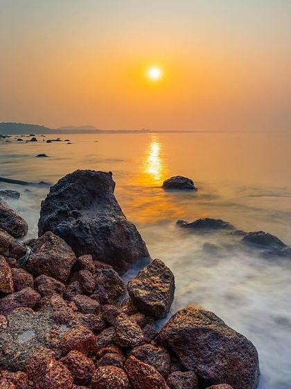A long exposure shot of the sunrise over Hollant beach in South Goa. The soft light and misty water create a tranquil and painterly effect.
