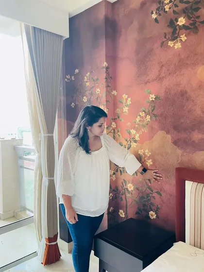 Here I am on-site, reviewing the final installation of the autumn-themed bedroom wallpaper, ensuring every detail and color is perfect.