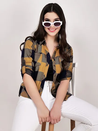 A smiling, seated pose brings a friendly and approachable vibe to this women's plaid shirt photograph.