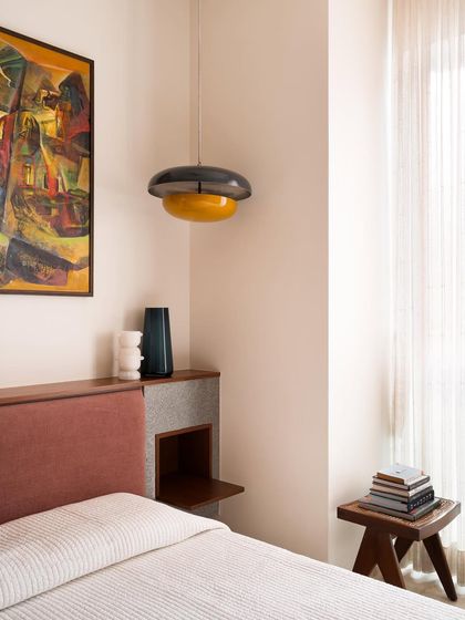 In this master bedroom, the custom headboard incorporates a small granite shelf. This detail provides a durable and beautiful surface for a lamp or personal items, blending storage directly into the bed's design.