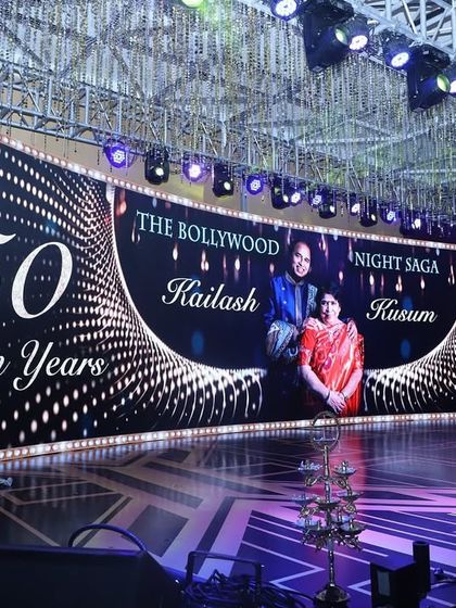 A close-up of the stage for the '50 Golden Years' anniversary celebration. The custom graphics on the curved LED screen tell the couple's story, making the decor deeply personal and memorable.