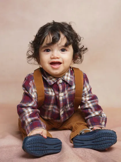 A classic studio portrait of a happy baby boy. With professional lighting and a simple backdrop, we focus on capturing your child's infectious smile and bright personality during our indoor baby photoshoots.