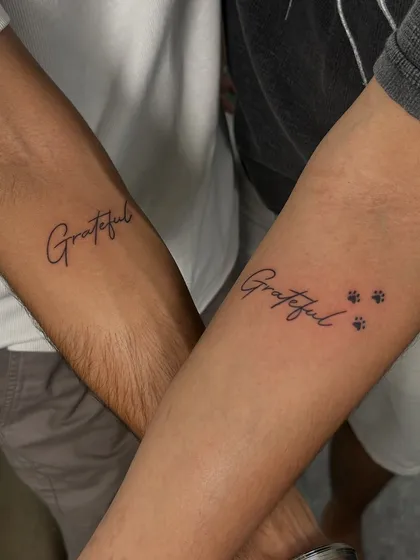 Sometimes, the simplest tattoos have the biggest meaning. This matching 'Grateful' tattoo for a couple is a beautiful example of fine-line script work. I added tiny paw prints to one, making it a personal tribute to their furry friend and their journey together.