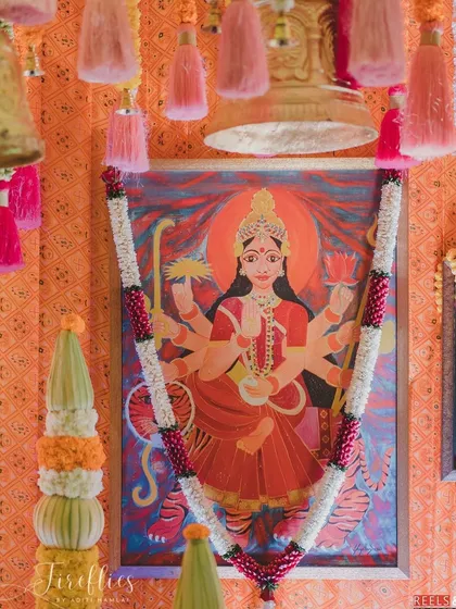A beautiful painting of the goddess, adorned with a fresh flower garland, serving as the focal point for the Mata ki Chowki ceremony.
