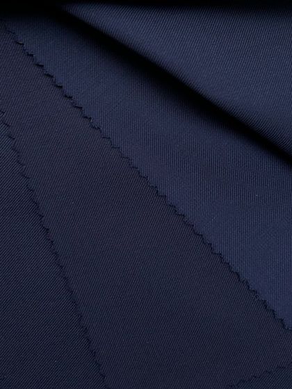 A close-up of a dark navy wool fabric, showing its fine weave and luxurious finish.