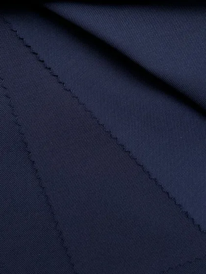 A close-up of a dark navy wool fabric, showing its fine weave and luxurious finish.
