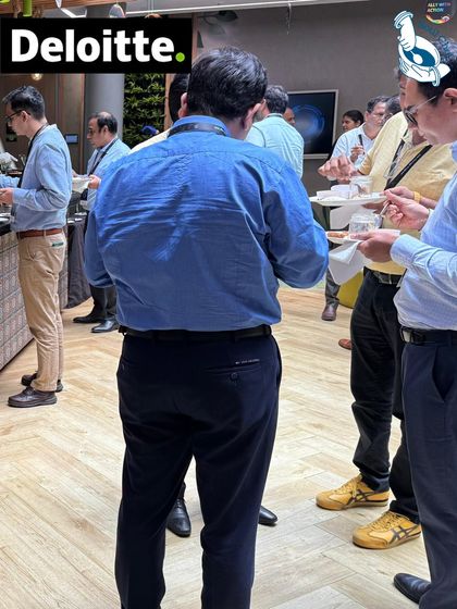 A candid shot of guests enjoying the food at a Deloitte corporate event. Seeing people gather, connect, and enjoy the culinary experience I've created is the most rewarding part of my work.
