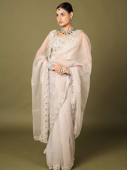 A full-length view of a model wearing our diamond necklace collection. This image showcases how our pieces can elevate a simple, elegant saree.