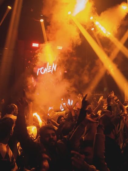 Golden light beams and thick smoke create a dramatic effect over the dance floor at SinQ Nightclub. The lighting is a key part of my performance.