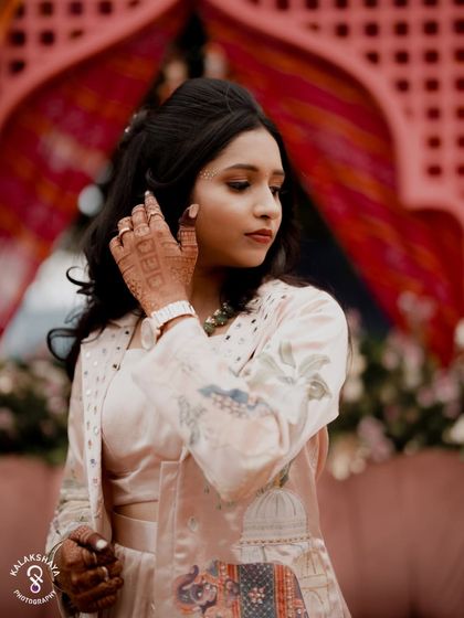 A candid portrait of the bride at her Sangeet, looking elegant against the colorful backdrop.