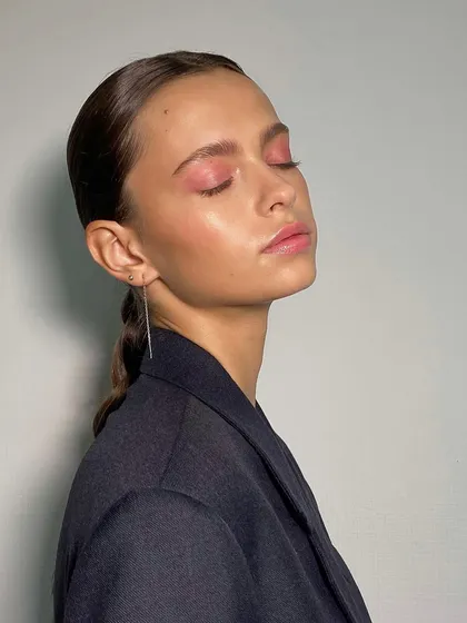A serene moment showcasing a finished look. The brows are styled to be airy and natural, complementing the soft makeup.