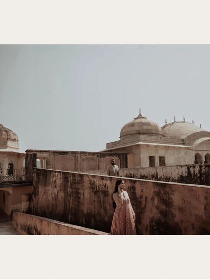 A wide shot of the couple on the ramparts of a fort, creating a sense of scale and history.