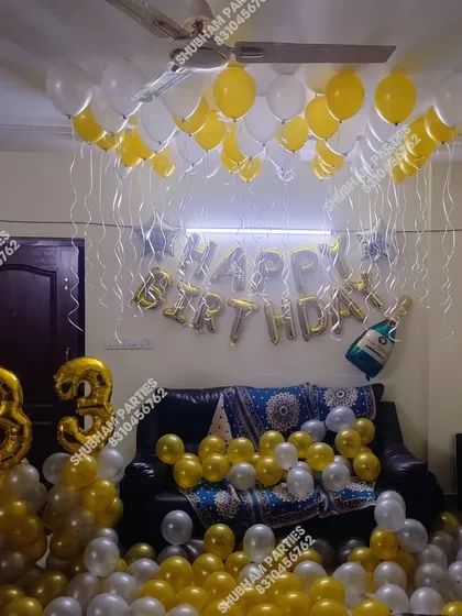 A grand 33rd birthday home party with the floor covered in yellow, white, and silver balloons.