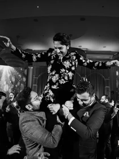 The groom lifted on shoulders during the reception party. I foster an environment where everyone feels free to celebrate with unrestrained joy.