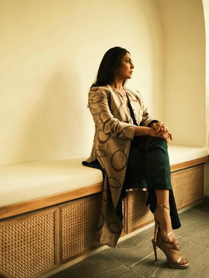 This shot reveals the stylish heels and the full length of the jacket, completing the elegant picture.