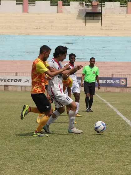A player skillfully maneuvering the ball on the sideline during our fourth game.
