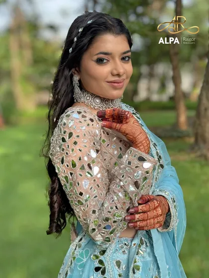A portrait of the Sangeet look, showing the glowing skin, silver jewelry, and a hairstyle that is both intricate and elegant.