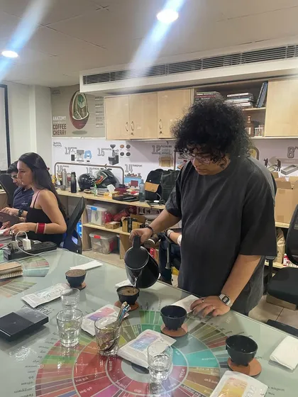 A student carefully pouring water for a cupping session. This process requires precision to ensure a fair and accurate tasting of different coffees.