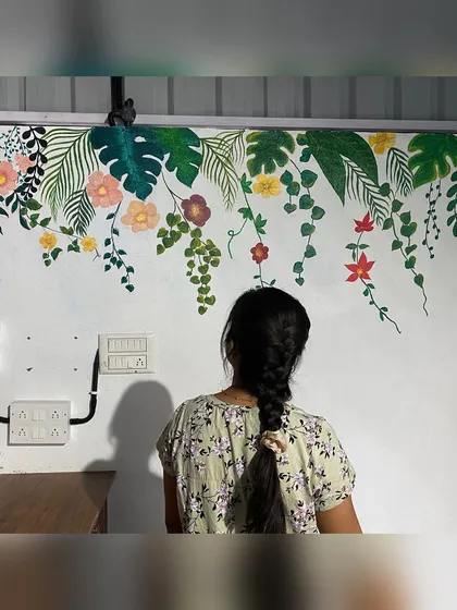 We love painting different styles of tropical murals. This one features hanging monstera leaves and floral creepers, creating a delicate and airy feel on the wall of a restaurant.