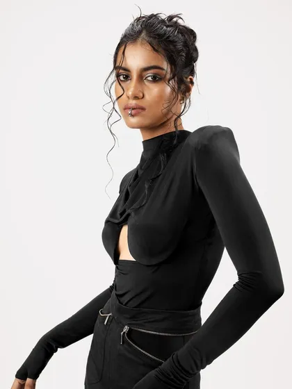 A close-up of a messy, artistic updo with carefully placed curly tendrils. The makeup is a defined smokey eye, creating a look that is both edgy and elegant for a fashion campaign.