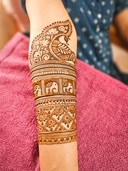 Another armband detail, this one combining a peacock with a row of marching elephants.