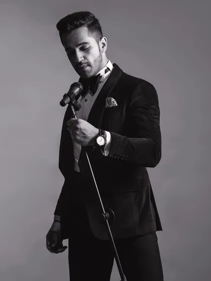 A black and white shot of the velvet tuxedo, emphasizing the timeless quality of the design. The play of light and shadow highlights the luxurious texture of the fabric.