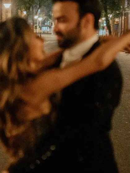 An artistic motion-blur shot of the couple dancing in the streets of Mumbai at night, capturing the movement and energy of the city.
