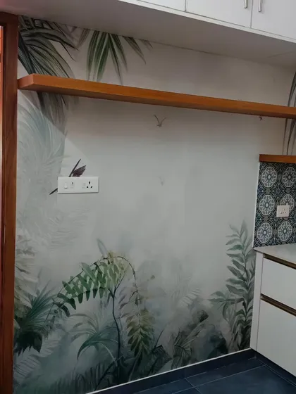 This kitchen wall is brought to life with a misty jungle wallpaper. The design adds depth and a touch of nature without overwhelming the clean, modern cabinetry.
