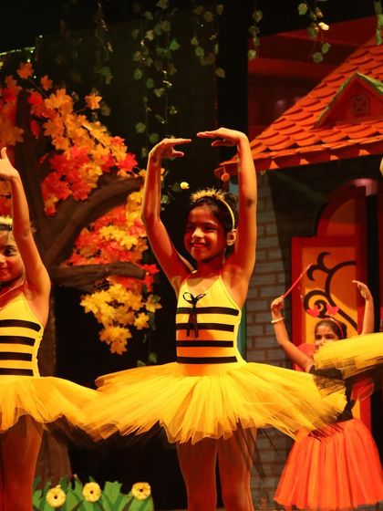 A close-up of a smiling bee. The joy of performance is evident on the faces of our youngest dancers.