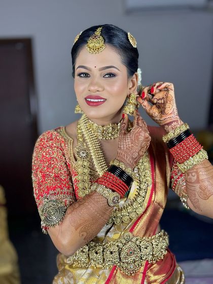 A candid moment of the bride adjusting her earring. Her makeup looks perfect from every angle.