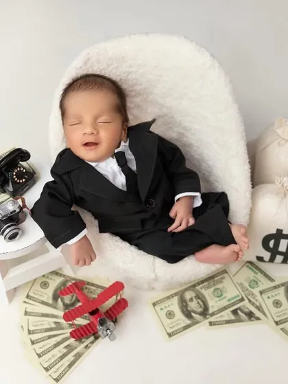 Even a boss needs a nap. This shot captures a sweet, sleepy smile, adding a layer of adorable humor to the 'boss baby' theme.