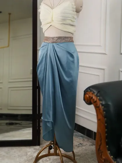 This ensemble is an ode to modern, understated romance. I paired a structured butterfly crop top with a gracefully draped satin skirt and an embellished belt to create a silhouette that is both modest and enticing.