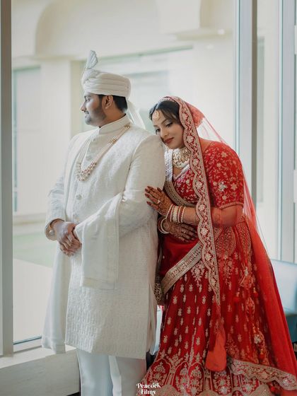 A quiet, intimate portrait of the couple by a window, the bride resting her head on the groom's shoulder.