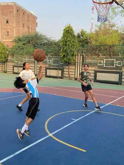 We welcome and train fierce competitors, both boys and girls. This shot captures one of our female athletes executing a perfect scoop layup, showcasing her skill and agility.