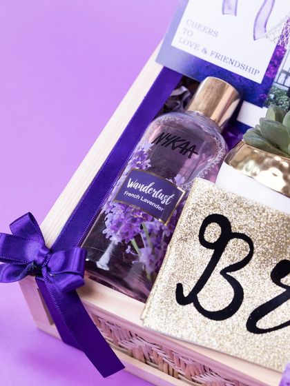 A close-up on the 'Bride' pouch and Nykaa Wanderlust body mist, key items in the pamper-themed bridal gift hamper.