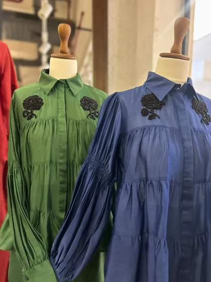 A detailed view of the green and blue tiered shirts, showcasing their relaxed fit and beautiful sleeve details.