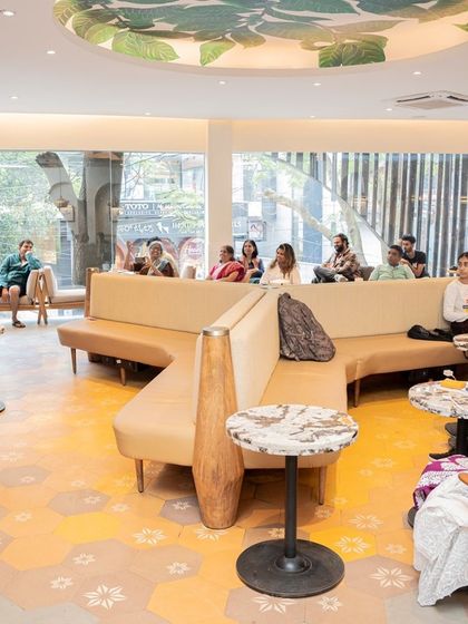 The audience at the "A Fly on The Wall" book launch, comfortably seated and enjoying the poetry reading in a bright, airy cafe.