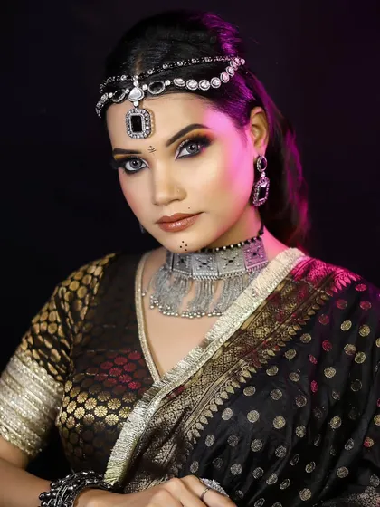 A portrait showcasing the complete look, with the model wearing a black and gold saree. This is a perfect example of a modern ethnic party look.
