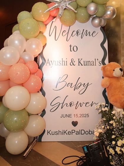 The charming welcome sign for Ayushi and Kunal's baby shower, complete with cute teddy bears and a soft pastel balloon garland.