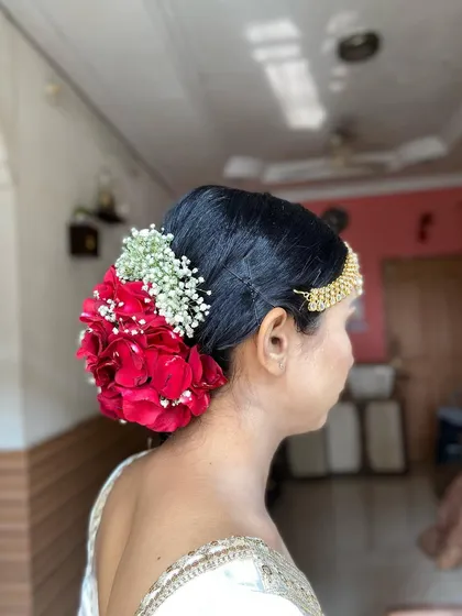 Another angle of the rose bun, showing how it complements the bride's traditional jewelry.