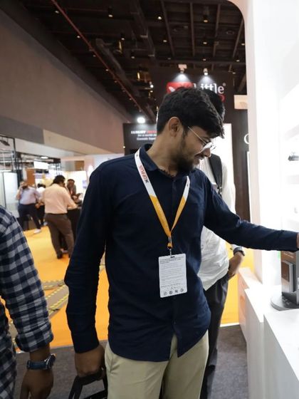 An attendee interacts with a smart lock display, testing its mechanism and design. The hands-on experience is a key benefit for visitors evaluating new products.