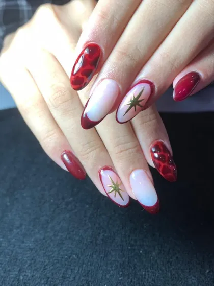 A bold red set with a mix of styles, including a snakeskin pattern, French tips, and gold star accents.